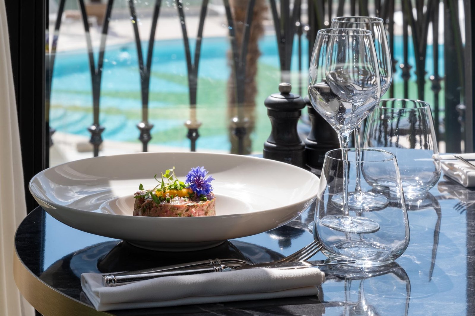 Un tartare de saumon posé dans une assiette avec des fleurs. Basse-Goulaine Photographe.