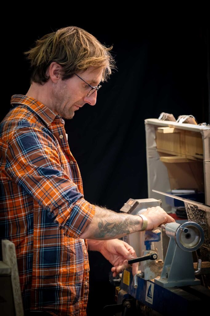 Menuisier, debout devant son tour à bois Flavien Photographe pour les artisans à NANTES
