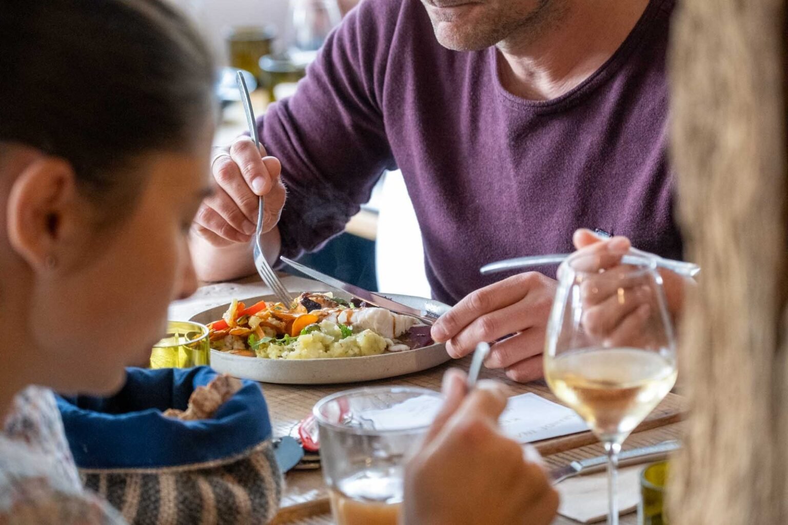 Des clients, assis à table, en train de déguster leur plat à NANTES