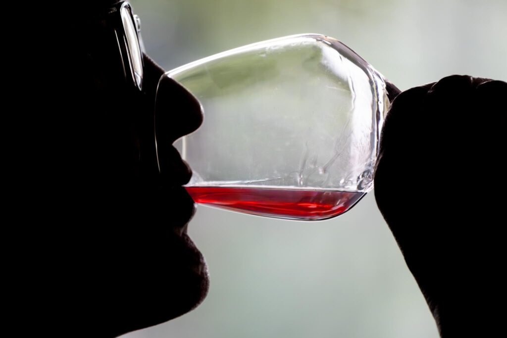 Un homme à contre-jour en train de déguster du vin rouge Flavien Photographe culinaire NANTES