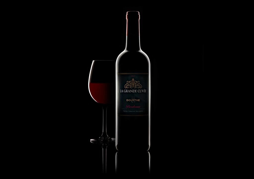 Bouteille de vin et verre sur fond noir